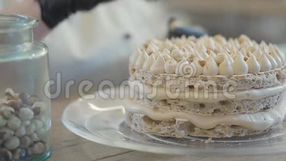 厨师在餐厅厨房的特写镜头里准备蛋糕厨师用通风的面团装饰最上面的蛋糕层视频的预览图