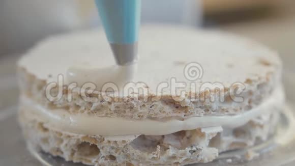厨师在餐厅厨房的特写镜头里准备蛋糕厨师用通风的面团装饰最上面的蛋糕层视频的预览图