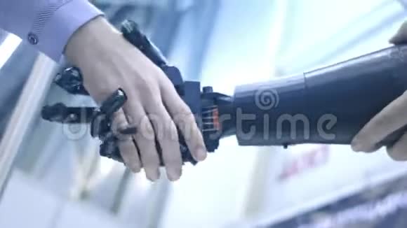 未来就是现在年轻学生科学家发明家的男性手摇动机器手臂一个男人和机器人握手视频的预览图