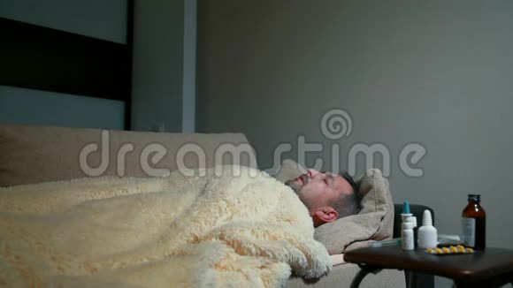 一个中年男子躺在一张地毯下沙发上温度很高视频的预览图