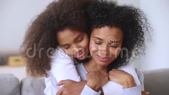 女儿拥抱母亲闭上眼睛享受温柔特写的时刻视频的预览图