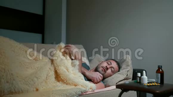一个中年男子躺在一张地毯下沙发上温度很高视频的预览图