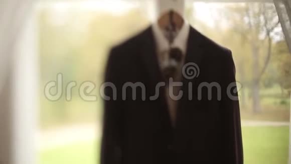 在新郎婚礼前一个男人的夹克和西装挂在一个衣架上挂在视频的预览图