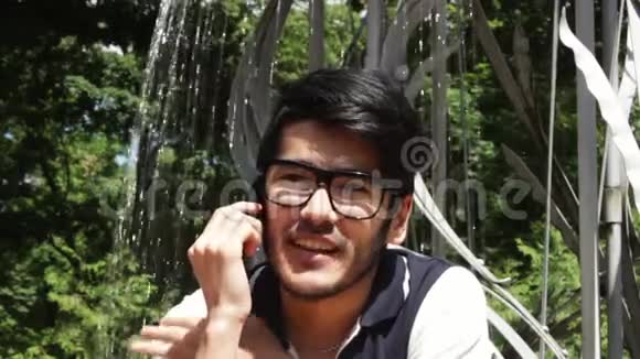 亚洲学生男子通过电话交谈视频的预览图