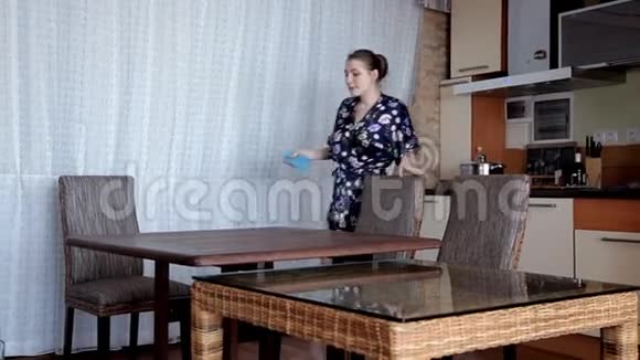 早上一个年轻的女孩在跳舞时打扫厨房好心情视频的预览图