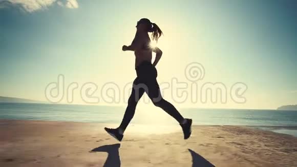 日出时在海边奔跑的女人强壮的运动员早上做运动视频的预览图