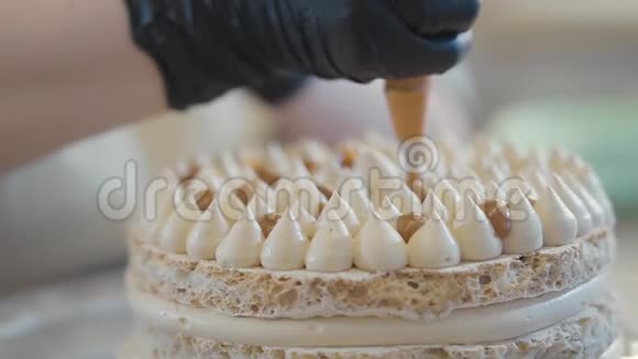 统一着装的糖果师把刚煮好的甜奶油或奶油蛋糕和糕点袋装饰视频的预览图