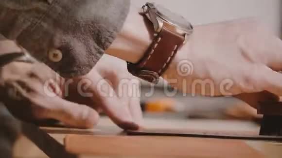 专业男工手工手工抛光皮革的特写镜头用专用磨砂刷抛光视频的预览图