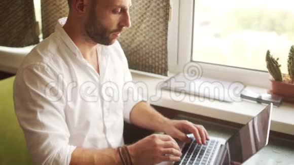 动态画像一个穿白色衬衫的人通过笔记本电脑在互联网上工作财务咨询视频的预览图