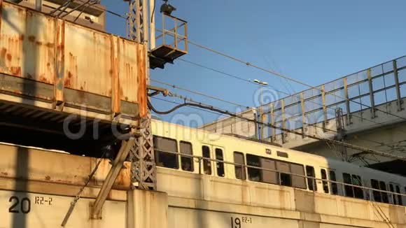 日本一列火车在日落时分穿过一座生锈的桥和公路视频的预览图
