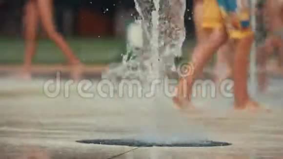 在公共公园里孩子们的脚在喷泉里玩耍和奔跑浅深的田野色调的视频视频的预览图
