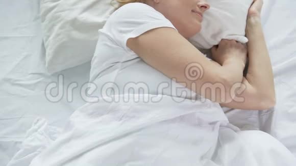 早上睡在床上的中年女性可以俯瞰双手放松视频的预览图