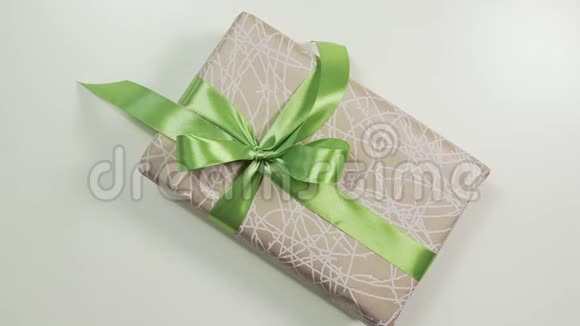 女人的近景她的手在现盒上系了一个蝴蝶结用漂亮的纸把礼物包起来视频的预览图