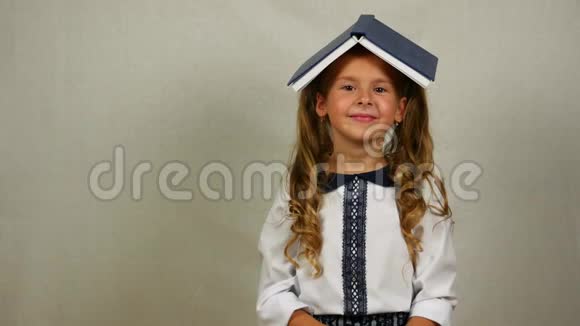 头上戴着书的女孩微笑着回到学校的概念视频的预览图