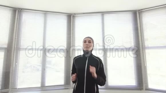 穿着头巾的女运动员在健身机上进行健身训练视频的预览图