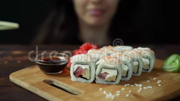 在咖啡馆里用筷子吃寿司的年轻女人视频的预览图