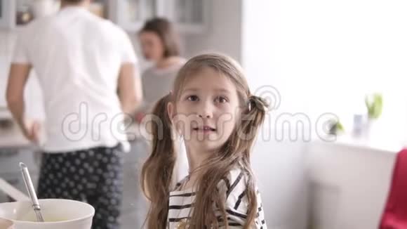 有着深色长发的小女孩在厨房里扔面粉视频的预览图