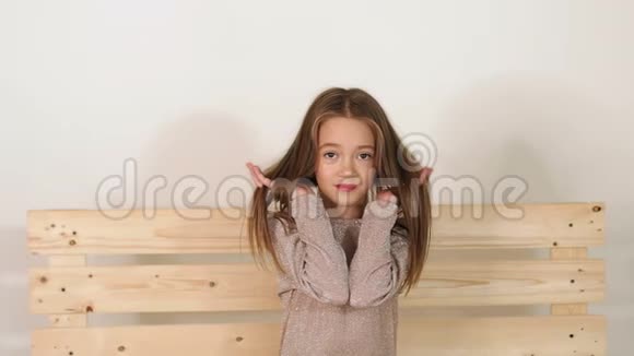 画室里有一个长发女孩的肖像她坐在一张木凳上视频的预览图