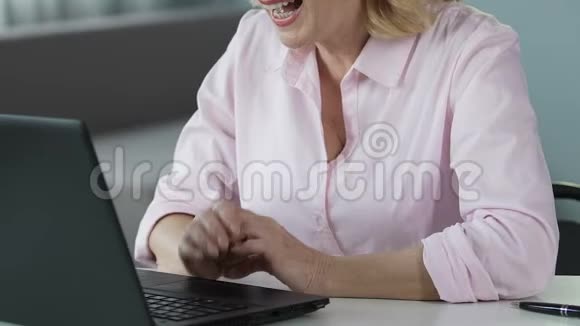 相当成熟的女商人在笔记本电脑上打视频电话和经理聊天视频的预览图