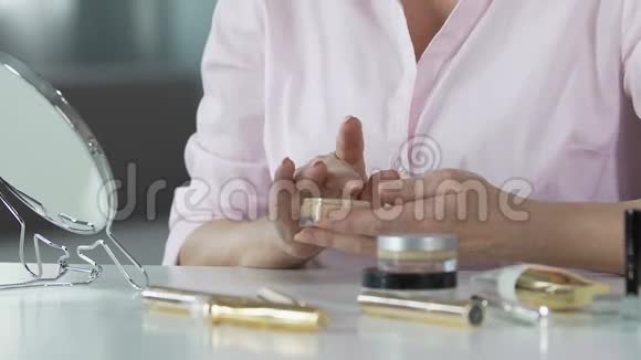 老年女性的双手在面部美容特写等部位打防年龄基础视频的预览图