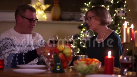 成熟的丈夫和妻子在一张满是蜡烛的桌子上一边喝着酒杯里的红酒一男一女视频的预览图