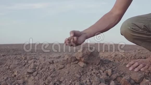人类手握土尘的慢动作视频干旱无雨的土地视频的预览图