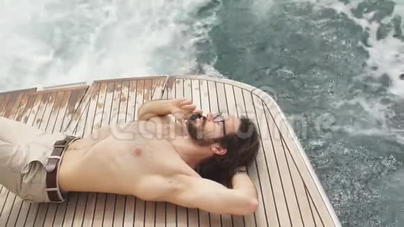 人在阳光下放松躺在海上的船上在岛上的游艇上进行豪华度假视频的预览图