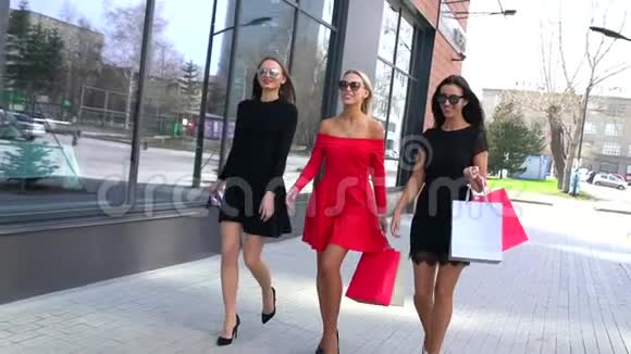 三个可爱的年轻女人走在街上享受他们的购物日穿着漂亮衣服的年轻女子视频的预览图