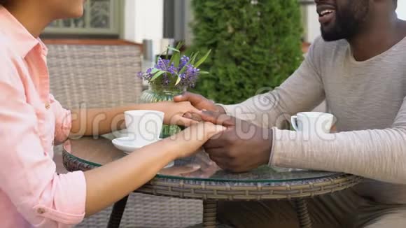 新婚夫妇幸福地牵着手在咖啡馆里聊天一起喝着早咖啡视频的预览图