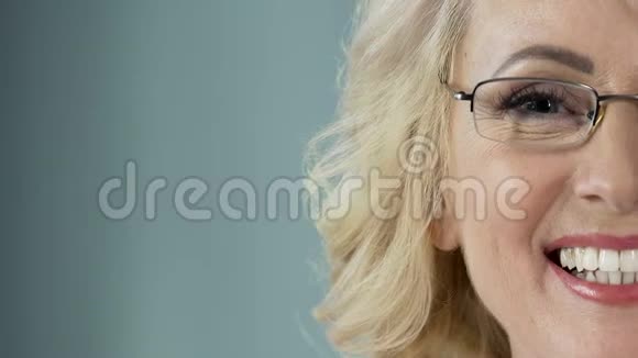 美丽的老年金发碧眼带着眼镜对着镜头微笑医疗保健视频的预览图