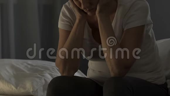 沮丧的成熟女士坐在床上头痛健康问题视频的预览图