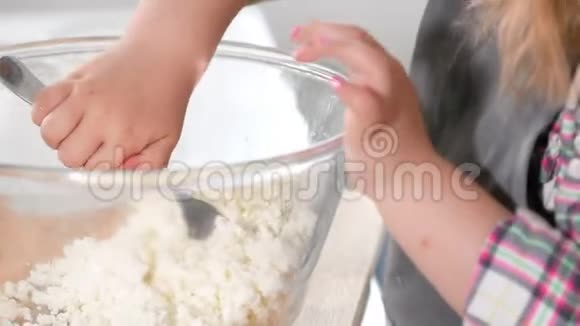 一个小女孩在烹饪工作室用一个玻璃碗里的叉子揉碎的干酪视频的预览图