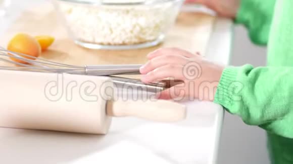 小女孩的手在玻璃碗旁边厨房里放着奶酪视频的预览图