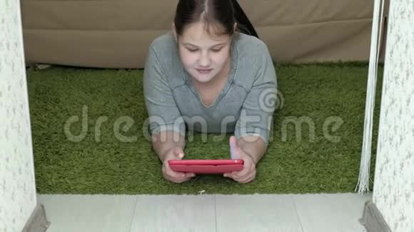 女孩在房间里玩平板电脑上网休息视频的预览图