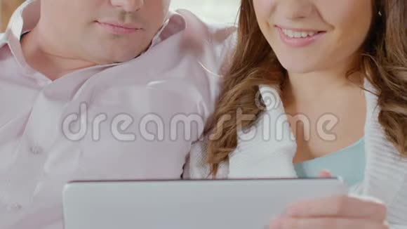 男人和女人看着平板电脑微笑着数码照片快乐的回忆视频的预览图