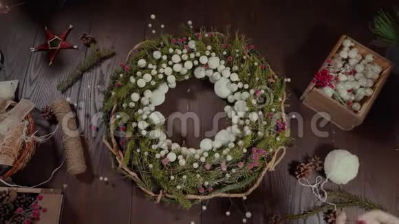 在工艺背景上的顶级圣诞花环漂亮的女人手准备圣诞常绿树花视频的预览图