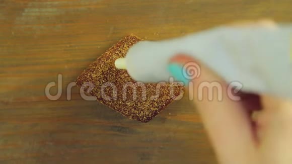 一只手握着一管烹饪颜料在带有黄色颜料的巧克力饼干上画一个百分号视频的预览图