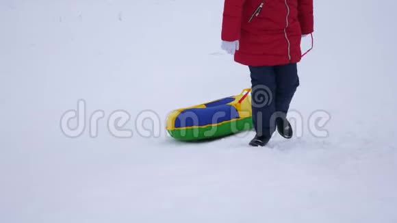 少女手持雪碟爬上雪山新鲜空气中的冬季游戏圣诞节视频的预览图