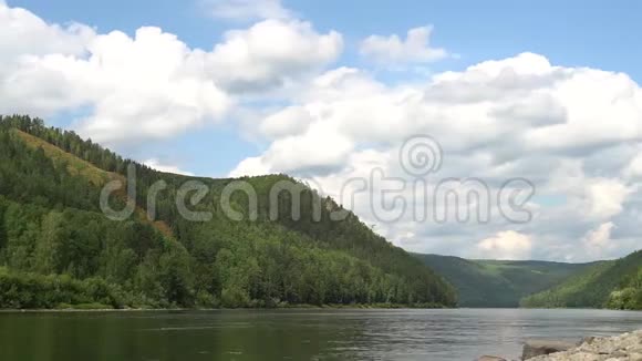 河流上方快速移动的体积云的夏季风景视频的预览图