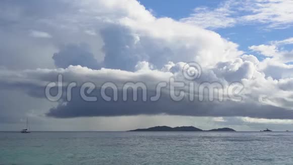 塞舌尔普拉斯林岛神奇的海景清澈的碧水和天空孤独的帆船在遥远的海洋里雨水视频的预览图