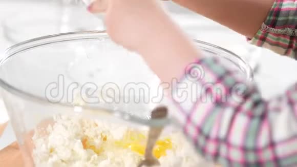 小女孩在烹饪室把鸡蛋放在面团里做奶酪薄饼视频的预览图