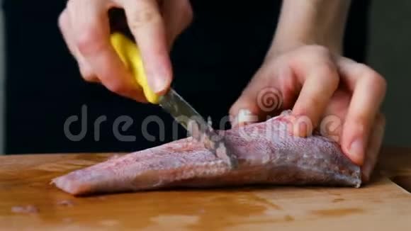 女人用刀在切割板上清洗鱼烹饪海鲜特写视频的预览图
