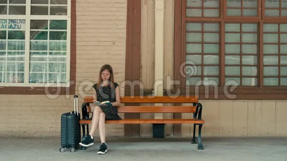 白人妇女正在车站站台等火车正在看书视频的预览图