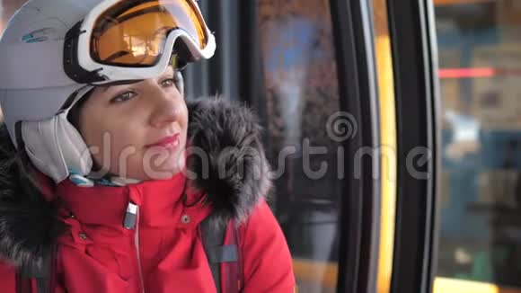 近距离微笑可爱的女滑雪者坐在滑雪缆车上视频的预览图