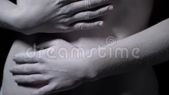 女人的双手抱着一个肚子女孩化妆成白色视频的预览图