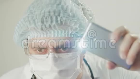 一位医生的特写镜头用智能手机灯笼突出病人的检查视频的预览图