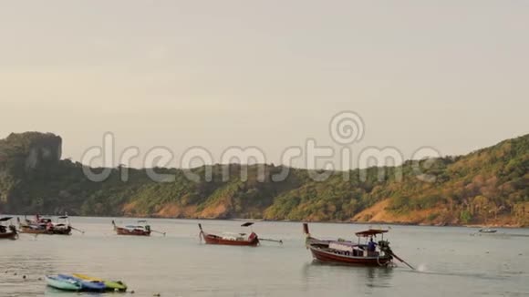 热带海洋海滩景观与停泊的小木传统彩色渔船4K视频的预览图