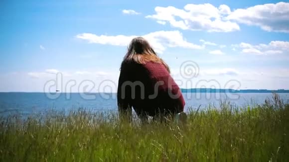 年轻女子坐在山上望着河燕子飞过水面视频的预览图