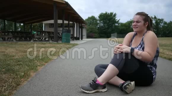 慢跑的女人在公园里跑步时膝盖受伤视频的预览图