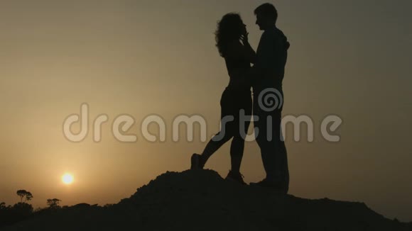 两个相爱的人的浪漫故事日落时分的情侣接吻剪影视频的预览图